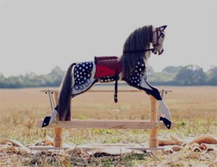English dapple grey rocking horse in a field